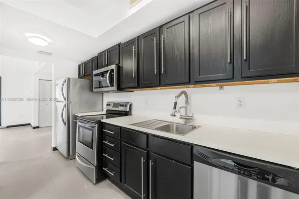 a kitchen with a sink appliances and cabinets