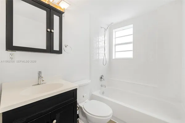 a bathroom with a toilet a sink a mirror and a bathtub