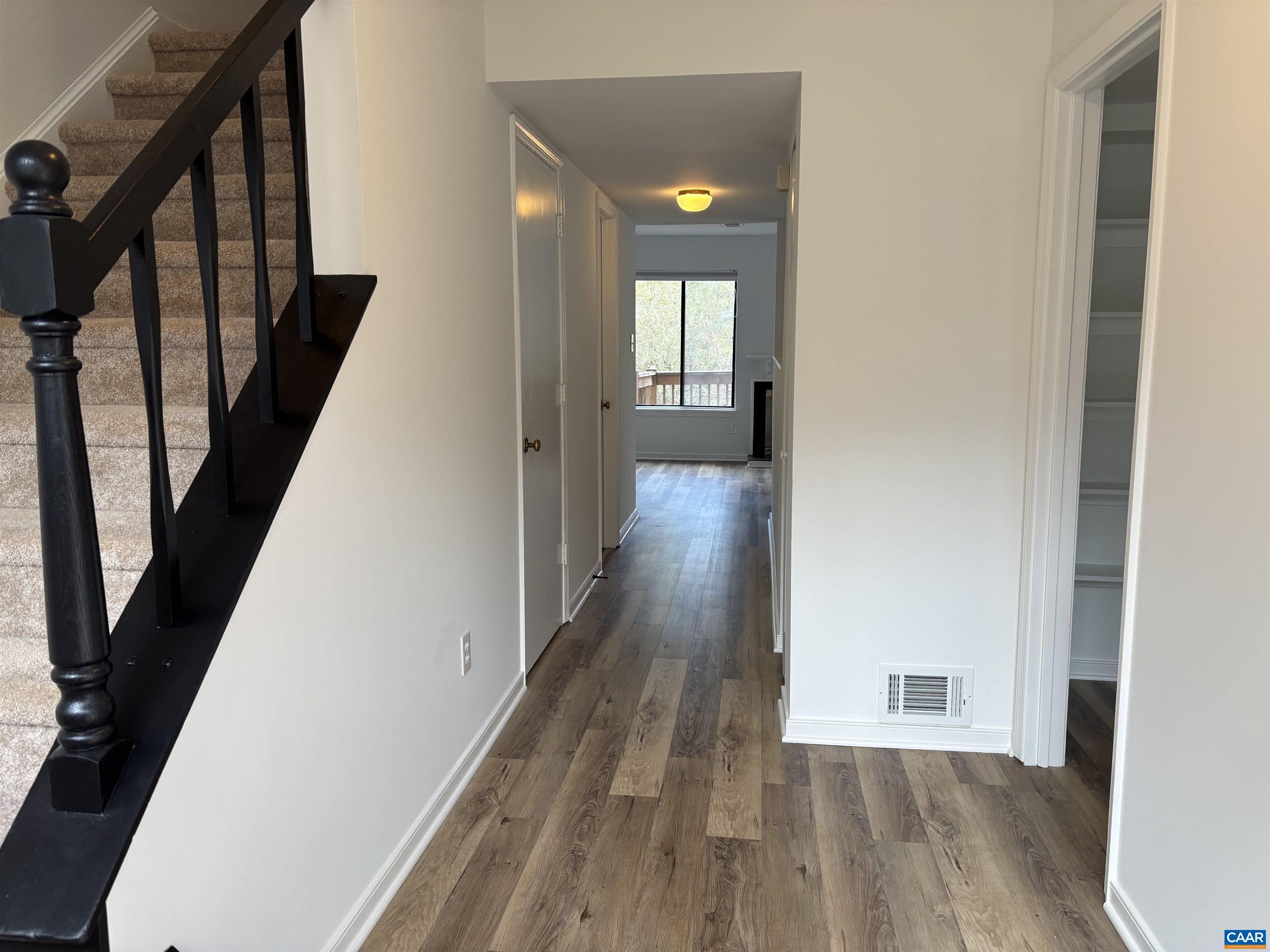 988 Salisbury Square Charlottesville, VA 22901 - Photo 4 of 17 a view of a hallway with wooden floor and staircase