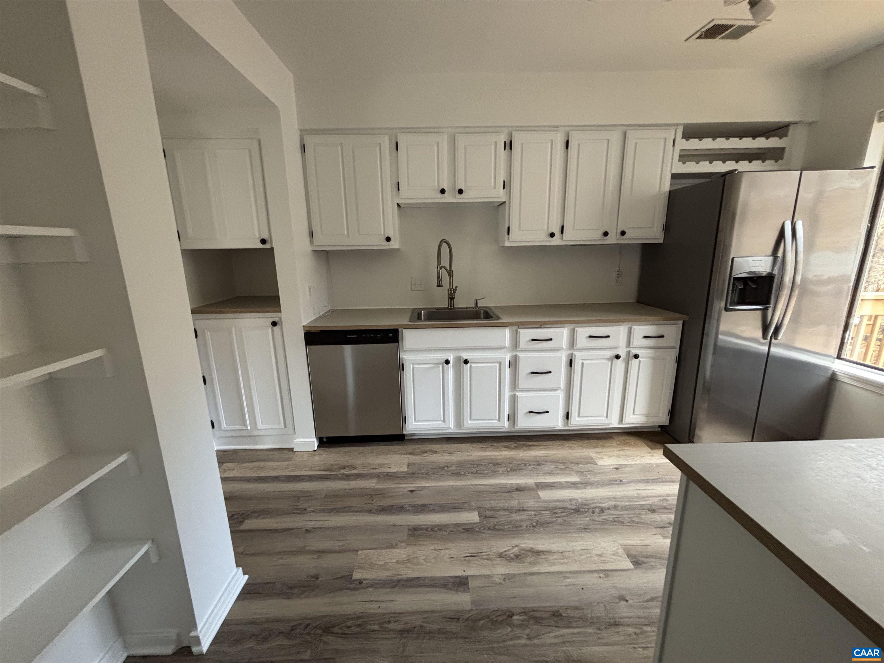 988 Salisbury Square Charlottesville, VA 22901 - Photo 7 of 17 a kitchen with granite countertop a refrigerator a sink and white cabinets