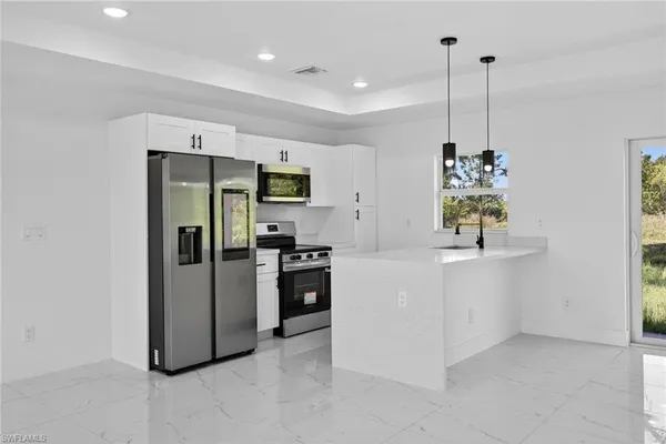 a kitchen with stainless steel appliances a refrigerator sink and stove