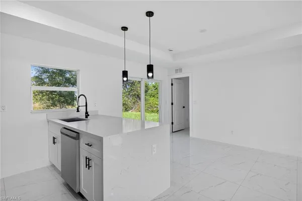 a kitchen with kitchen island a sink a stove and a wooden floor