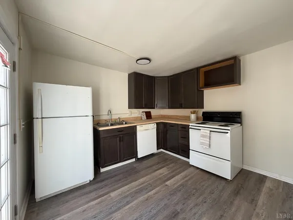 a kitchen with a refrigerator stove and wooden cabinets