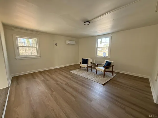 a living room with couches chairs and a coffee table with wooden floor
