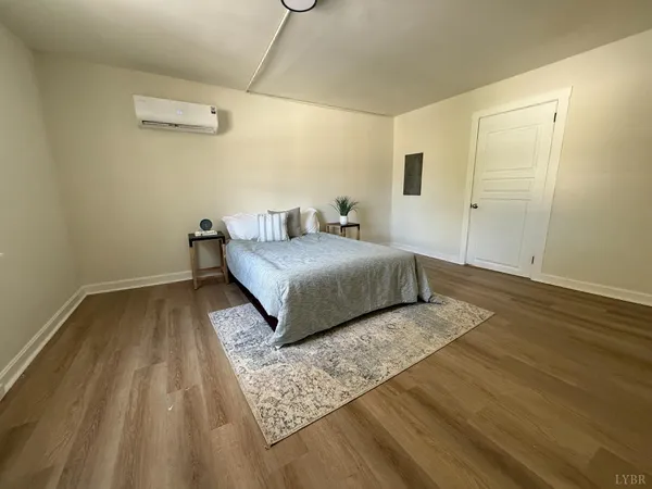 a bedroom with a bed and wooden floor