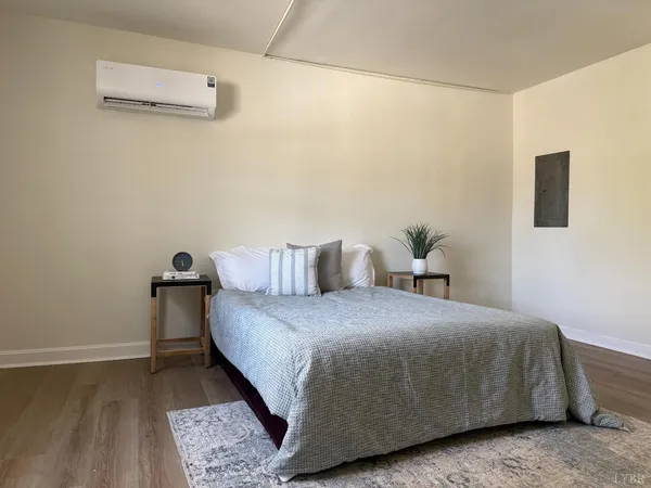 a bedroom with a bed and wooden floor