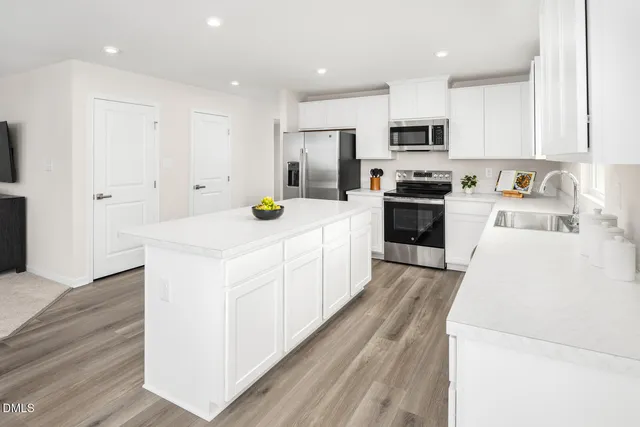 a kitchen with a dining table chairs and wooden floor