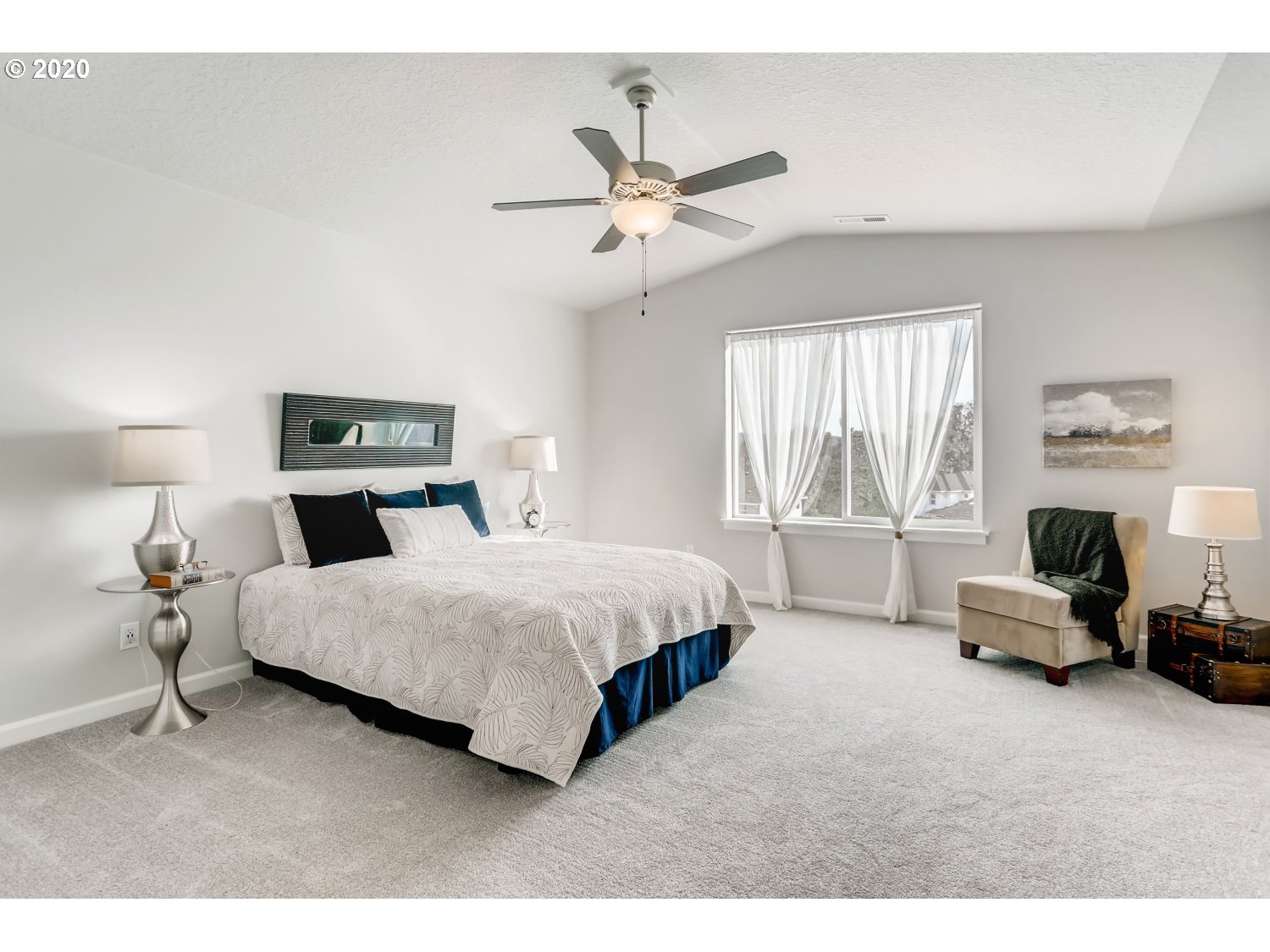 1550 19th Avenue Forest Grove, OR 97116 - Photo 15 of 26 a spacious bedroom with a bed a couch and a chandelier