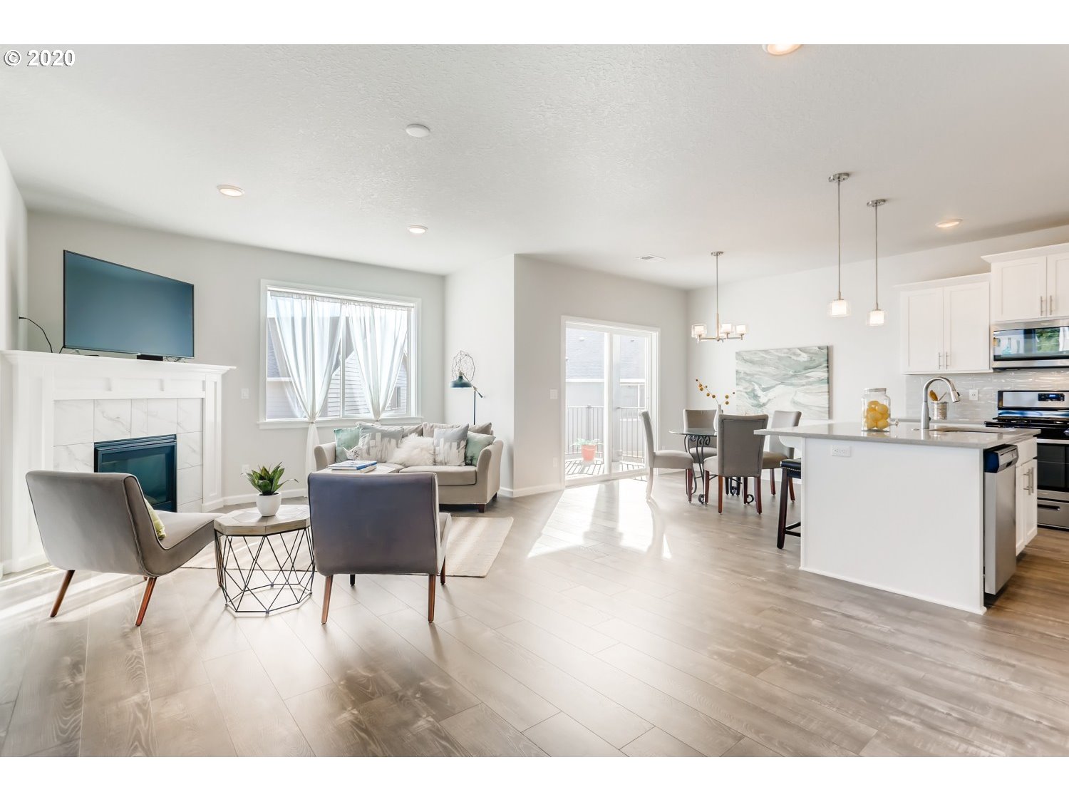 1550 19th Avenue Forest Grove, OR 97116 - Photo 8 of 26 a living room with furniture a fireplace a flat screen tv and kitchen view