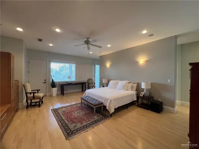 a spacious bedroom with a bed a table and potted plant