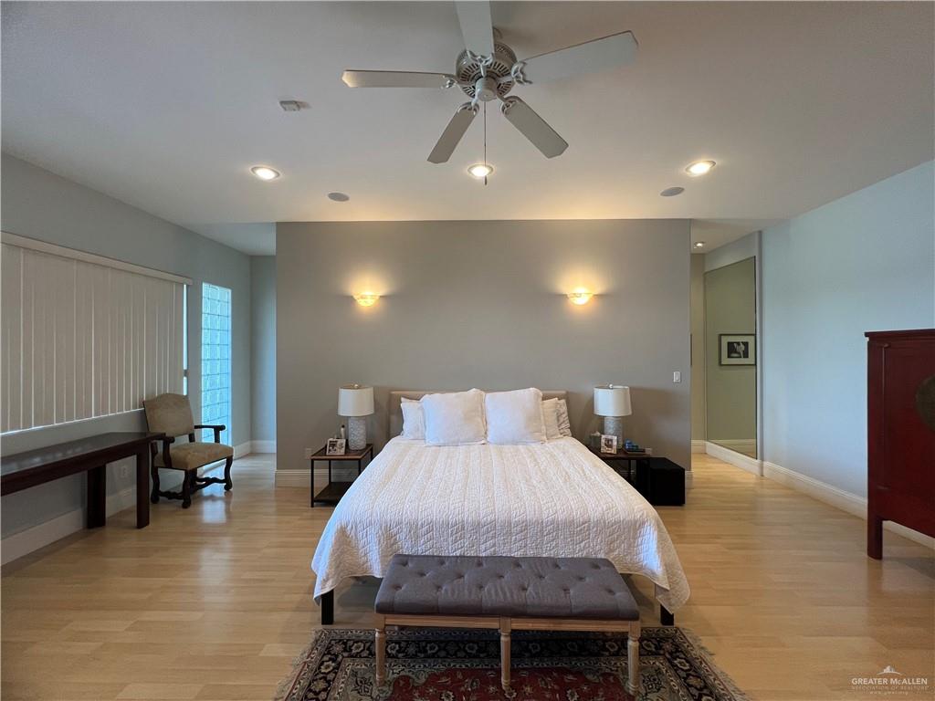 416 Frio Street Mission, TX 78572 - Photo 23 of 35 a spacious bedroom with a bed a table and potted plant