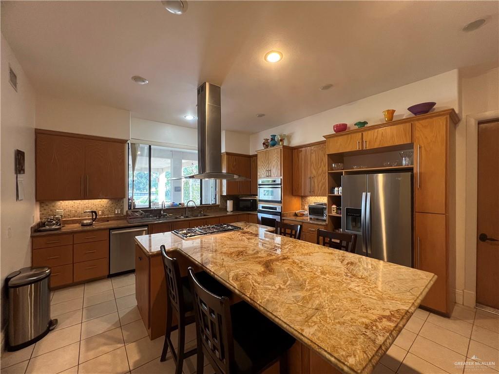 416 Frio Street Mission, TX 78572 - Photo 3 of 35 a kitchen with refrigerator and chairs