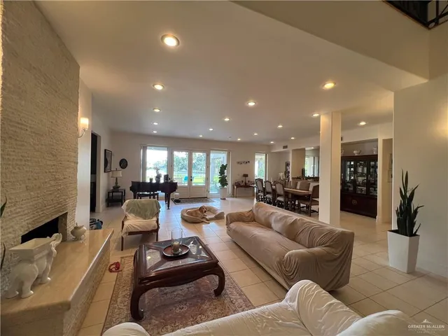 a living room with furniture kitchen view and a large window