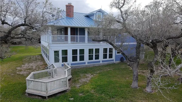 a view of a house with a yard deck and furniture