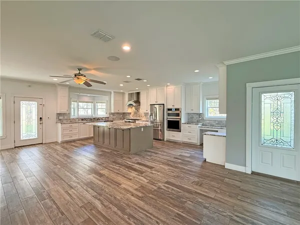 a large kitchen with cabinets wooden floor and a dining table
