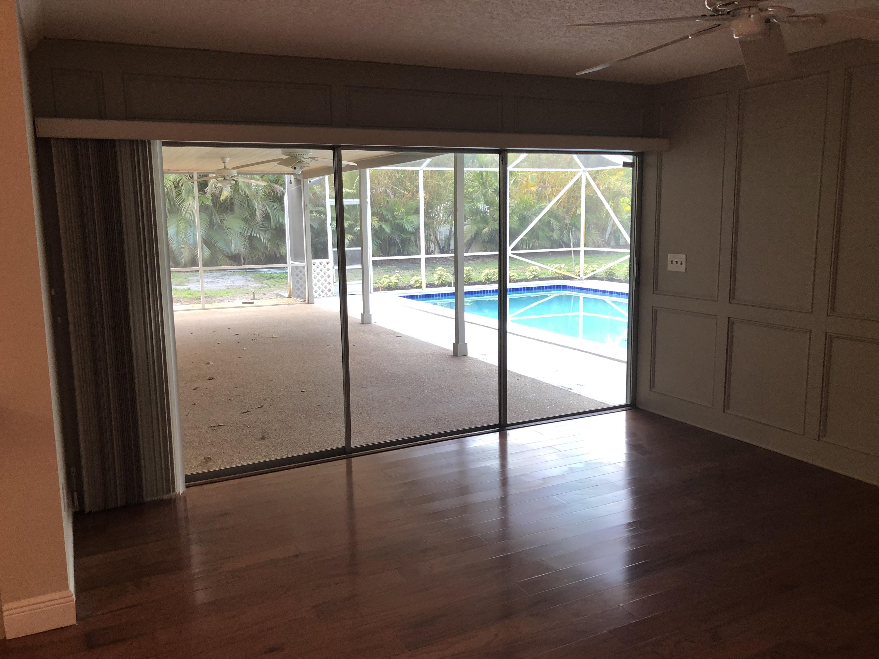 1229 Northwest Fork Road Stuart, FL 34994 - Photo 9 of 25 a view of an empty room with wooden floor and a window