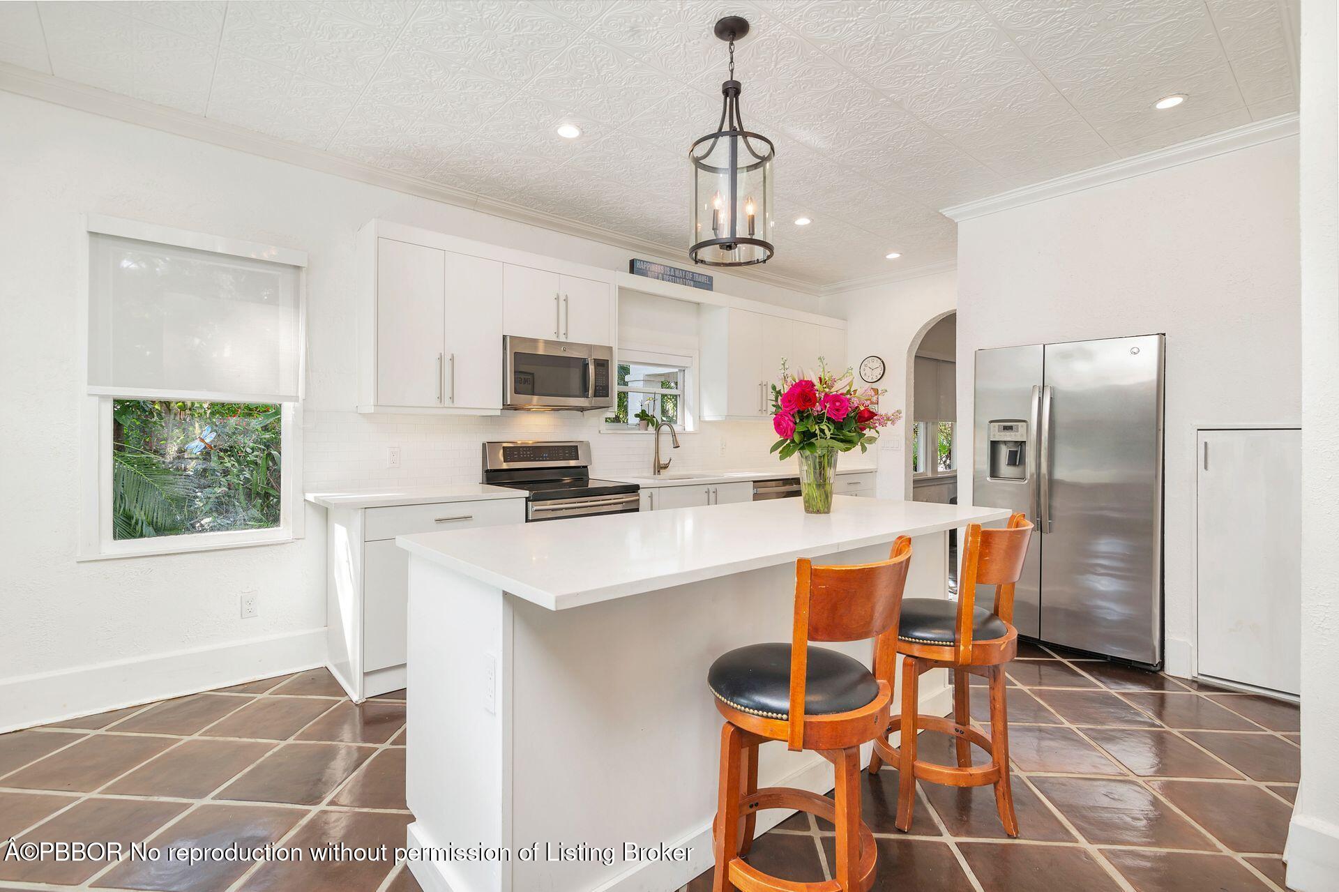 4112 Washington Road West Palm Beach, FL 33405 - Photo 12 of 41 a kitchen with stainless steel appliances kitchen island granite countertop a sink refrigerator and microwave