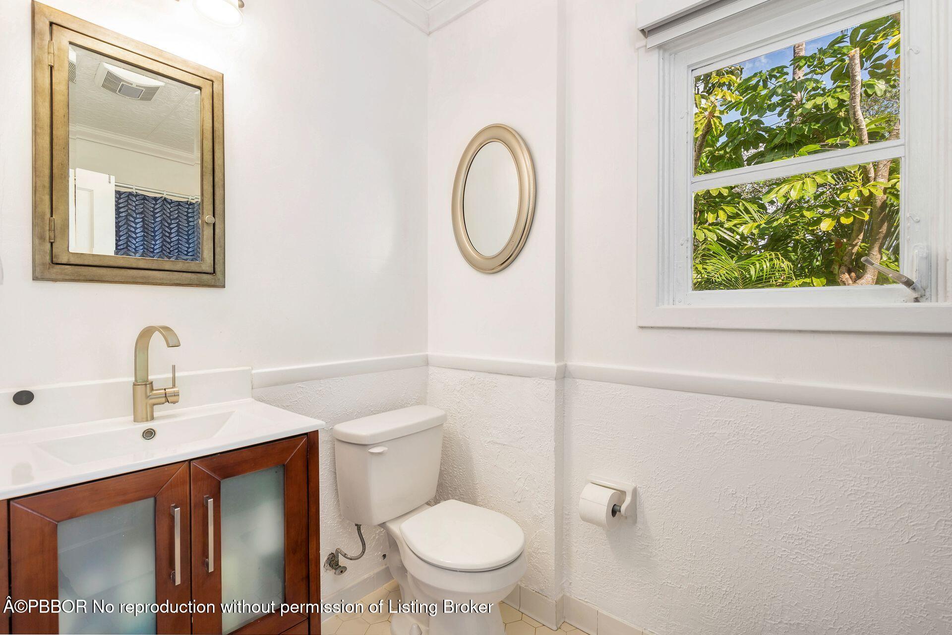 4112 Washington Road West Palm Beach, FL 33405 - Photo 21 of 41 a bathroom with a toilet a sink and a mirror