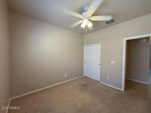 an empty room with a chandelier fan