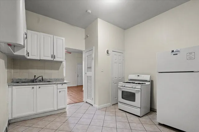 a kitchen with white cabinets and appliances