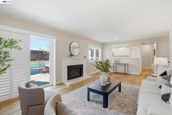 a living room with furniture a fireplace and a potted plant