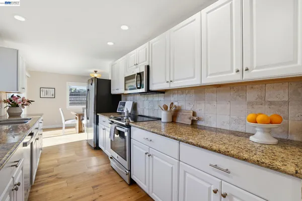 a kitchen with stainless steel appliances granite countertop a sink and cabinets