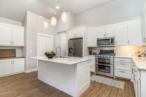 a kitchen with stainless steel appliances a sink stove and refrigerator