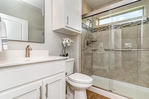 a bathroom with a sink a toilet and shower