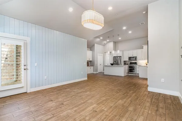 a view of kitchen with kitchen island wooden floor center island and appliances