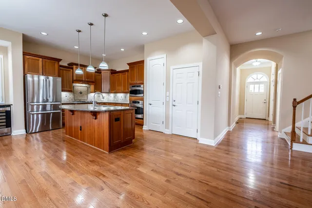 a large kitchen with stainless steel appliances granite countertop a large counter top and wooden floors