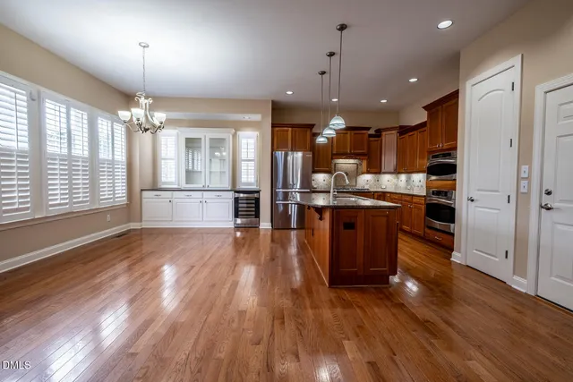 a open kitchen with stainless steel appliances granite countertop a stove and a wooden floors