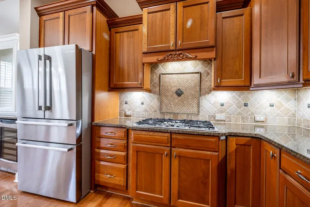 a kitchen with stainless steel appliances granite countertop a refrigerator and a stove top oven
