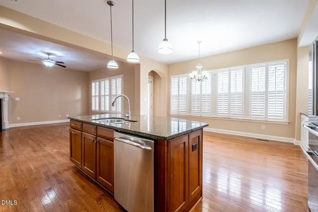 a kitchen with stainless steel appliances granite countertop a stove and a large window