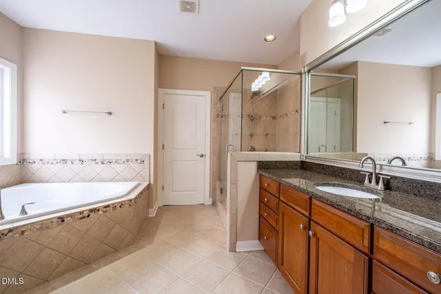 a spacious bathroom with a bathtub sink and mirror