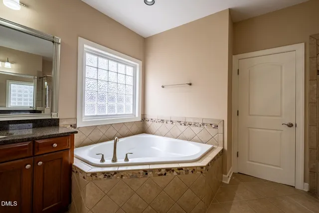 a bathroom with bathtub and window