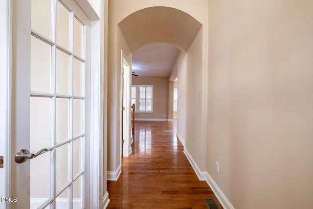 a view of a hallway with wooden floor and staircase