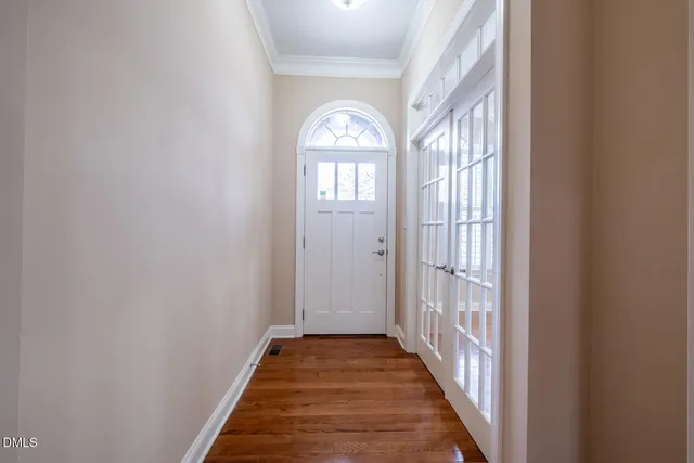 a view of a hallway with wooden floor and a window