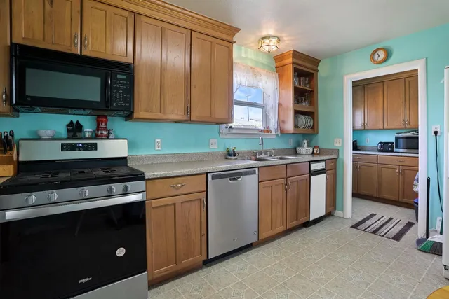 a kitchen with granite countertop a stove a sink and a microwave