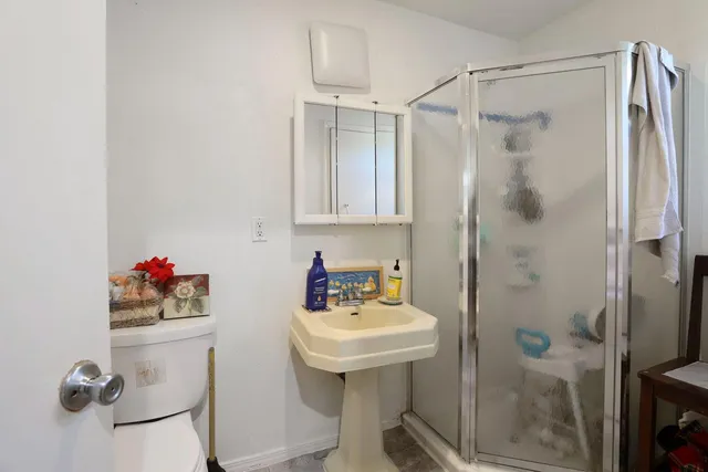 a bathroom with a sink mirror and shower