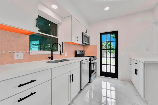 a kitchen with stainless steel appliances a sink stove and cabinets