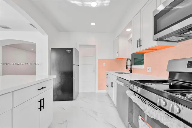 a kitchen with stainless steel appliances granite countertop a refrigerator and a stove top oven