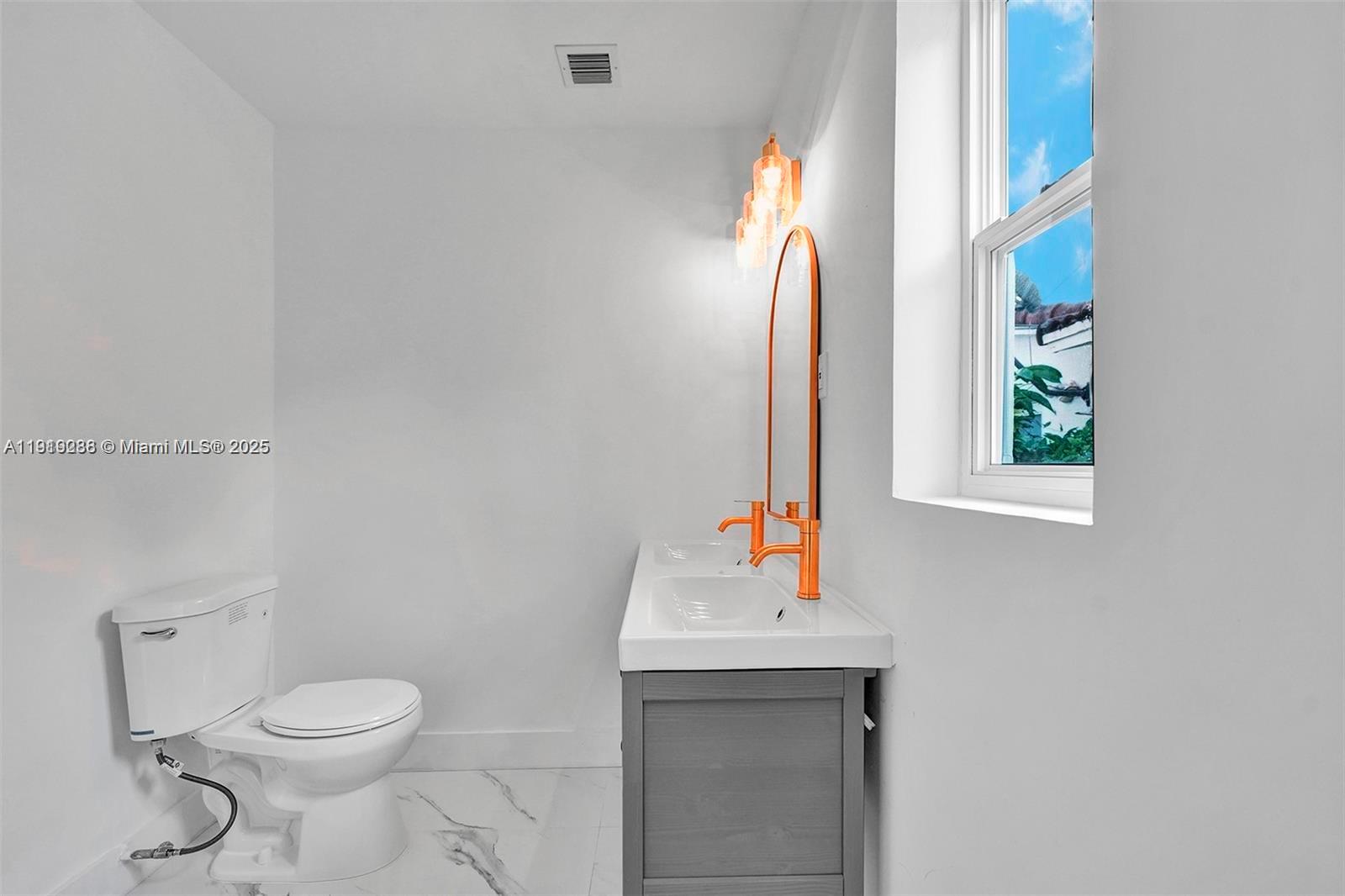 9173 Byron Avenue Surfside, FL 33154 - Photo 21 of 26 a bathroom with a toilet sink and mirror