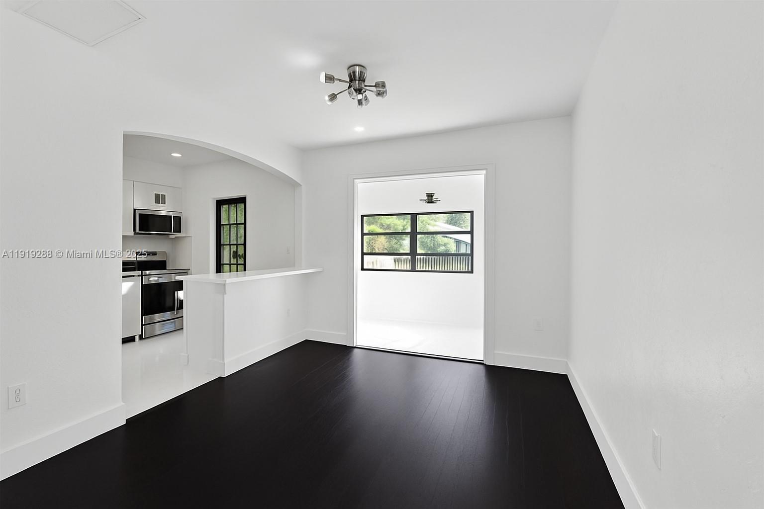 9173 Byron Avenue Surfside, FL 33154 - Photo 6 of 26 an empty room with wooden floor and windows