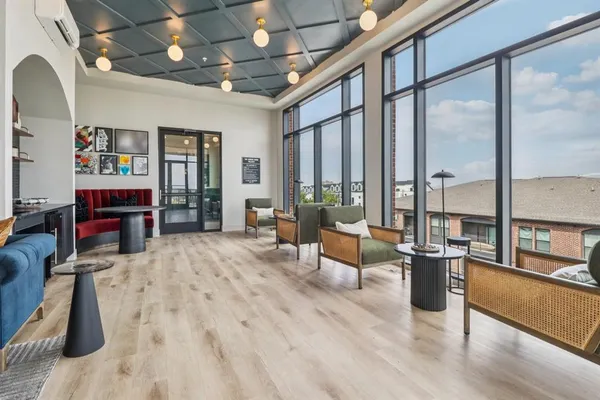 a living room with furniture a fireplace and a floor to ceiling window