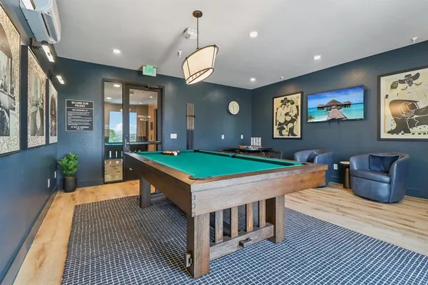 a room with furniture pool table and window