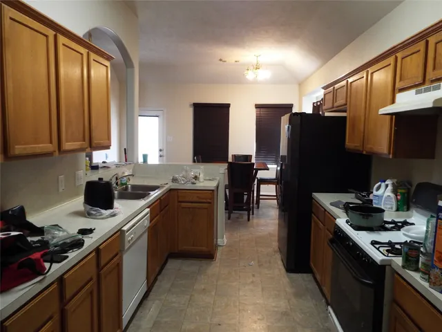 a kitchen with a sink stove and refrigerator