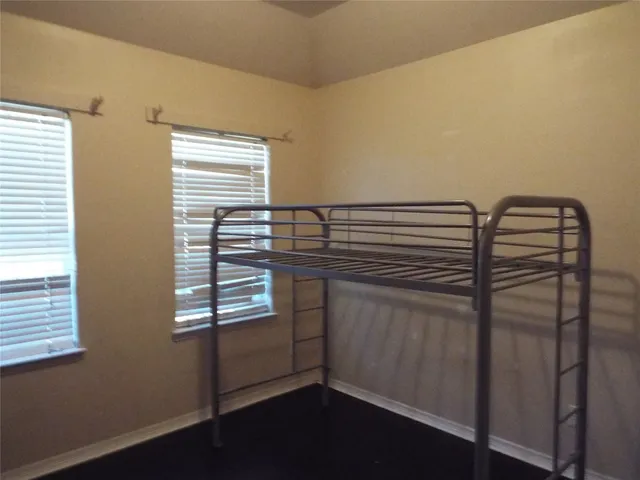 a kitchen with a refrigerator and white cabinets