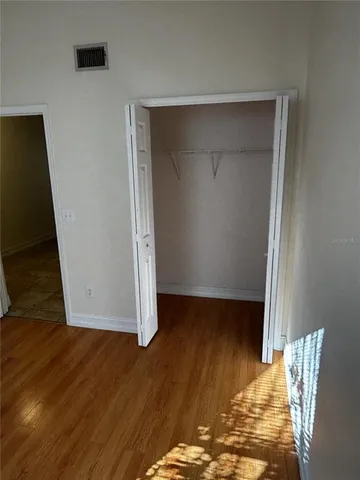 a view of an empty room with wooden floor