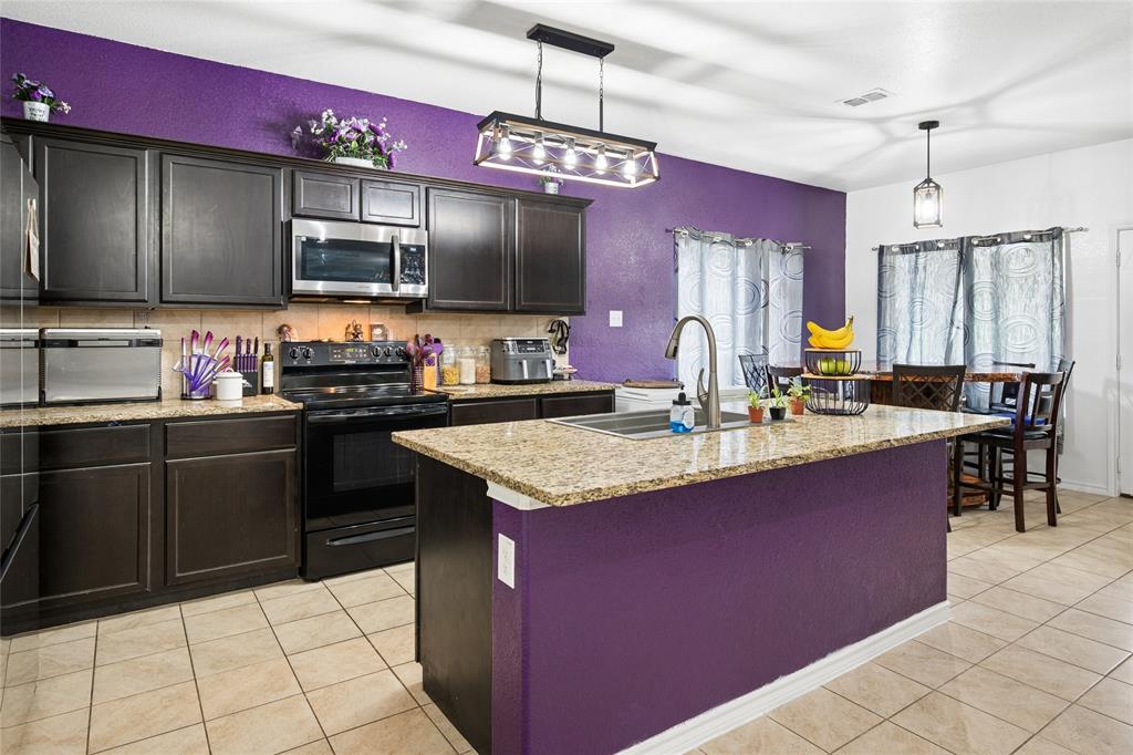 324 Fairgrounds Lane Ponder, TX 76259 - Photo 10 of 40 a kitchen with a granite counter top space a sink and appliances