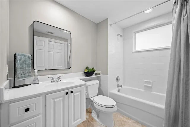 a bathroom with a toilet a sink a tub and mirror